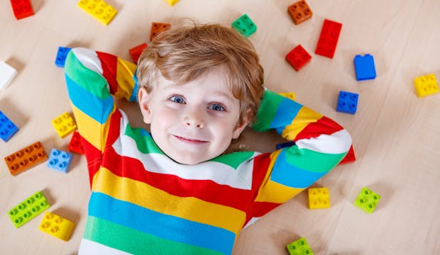 un enfant au milieu de Legos en couleurs