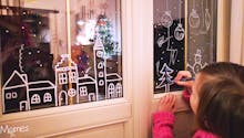 Dessiner des décorations de Noël sur les vitres de la maison