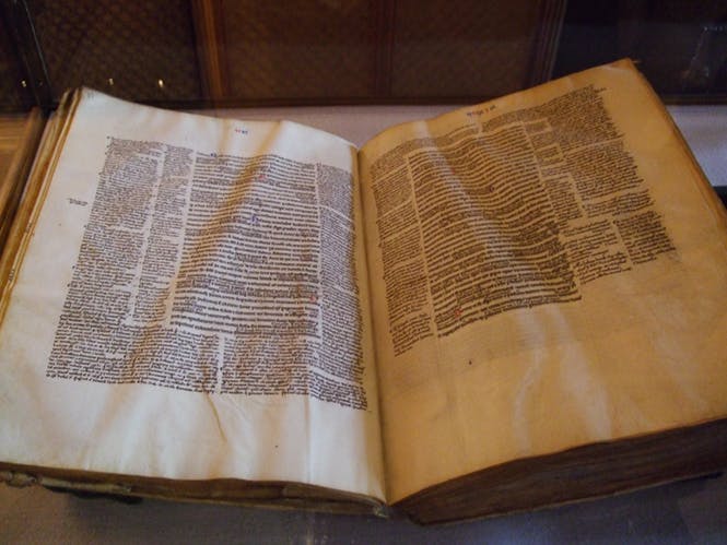 Un livre en parchemin, le texte a été copié à la main par un moine copiste.