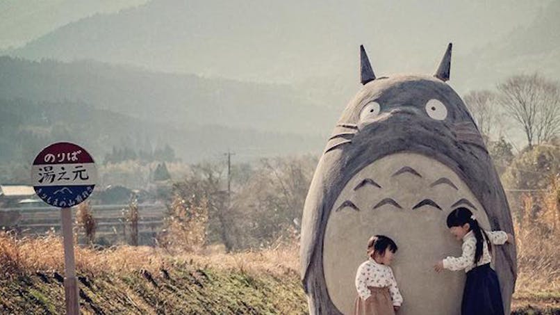 sculpture de Totoro et arrêt de bus avec des enfants qui
      jouent