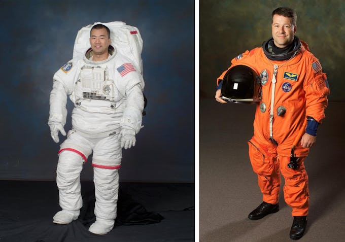 L'astronaute Soichi Noguchi dans sa combinaison extra-véhiculaire blanche et l'astronaute Nicholas J. M. Patrick dans sa combinaison intra-véhiculaire orange