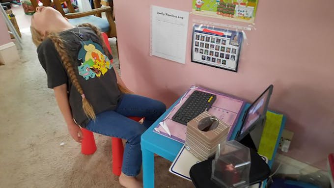 enfant qui s'ennuie devant un cours virtuel sur ordinateur