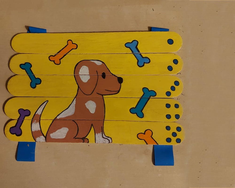 Un puzzle avec un dessin de chien fait à partir de bâtonnets