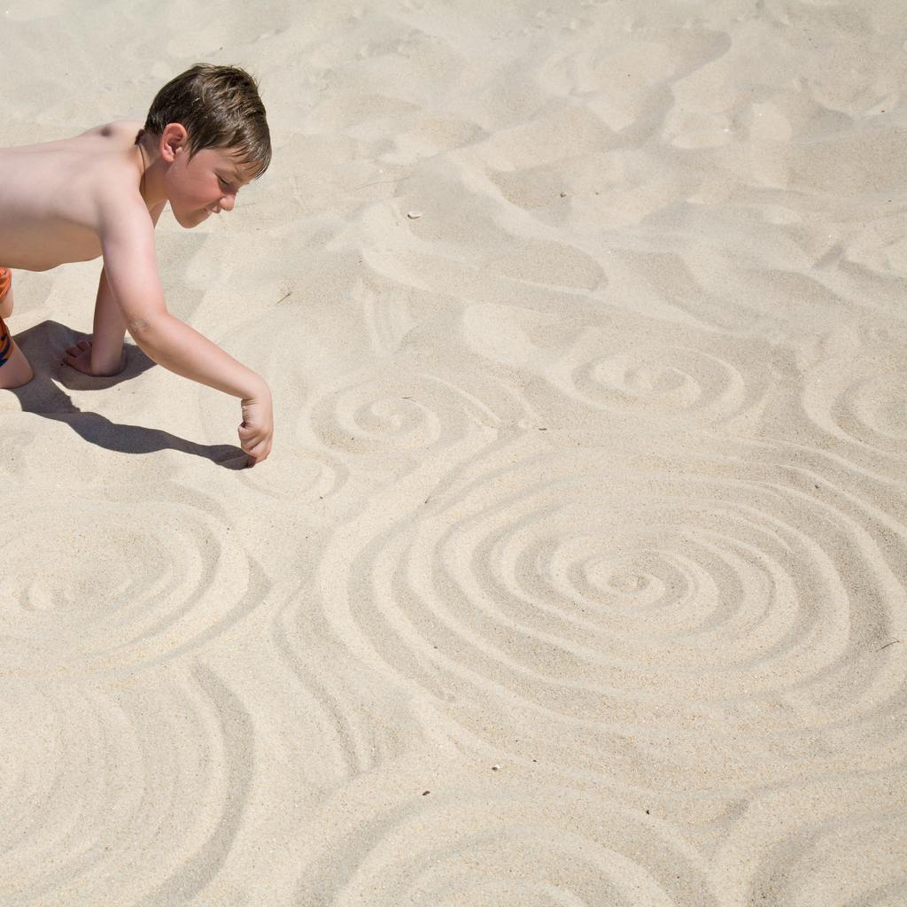 enfant-dessin-spirale-sable