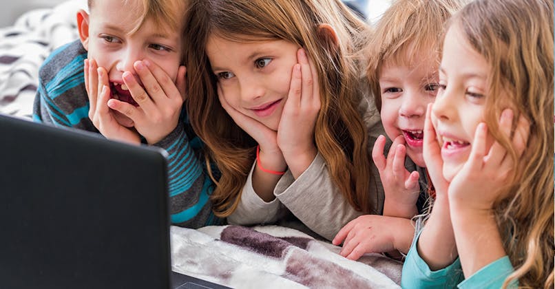 enfants qui regardent un dessin animé sur un ordinateur portable