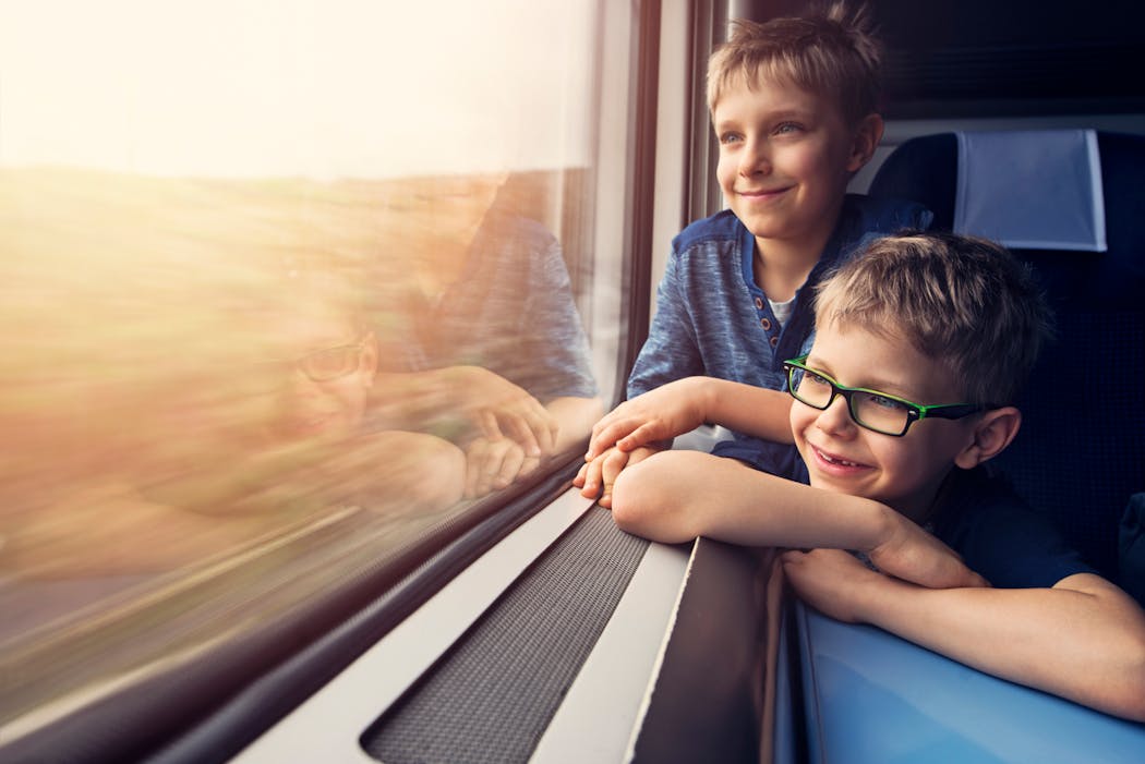 Deux enfants heureux qui regardent par la fenêtre d'un train 